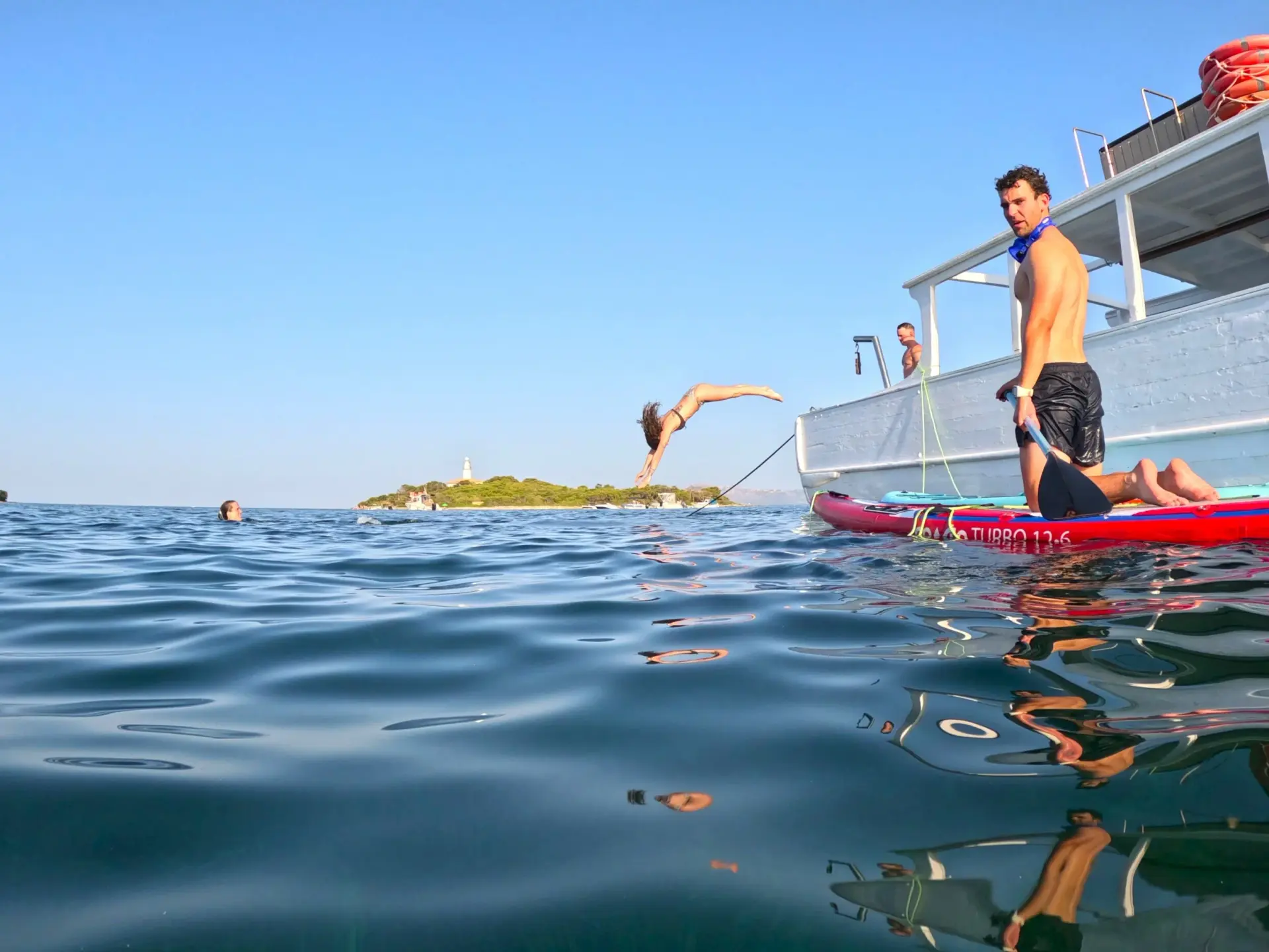 Sunset view from Coral Boats Mallorca cruise with silhouettes of passengers on deck